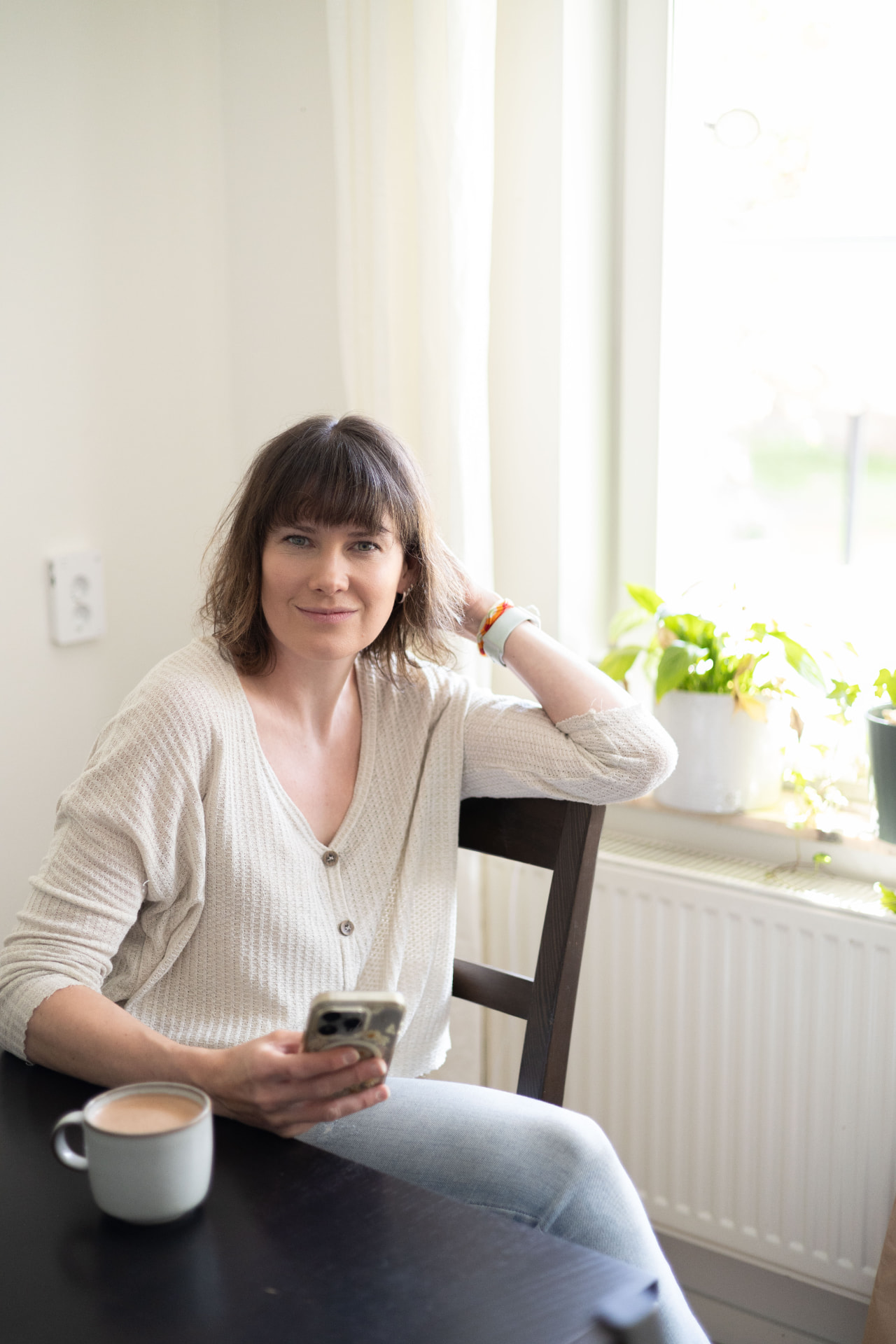 Sanni sitter hemma vid ett soligt fönster
